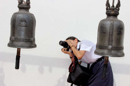 Una escolar fotografía una de las campanas del Golden Mountain, en Bangkok.