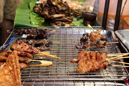 Brochetas de pollo y cerdo en uno de los puestos callejeros del Sunday Walking Street en Chiang Mai.