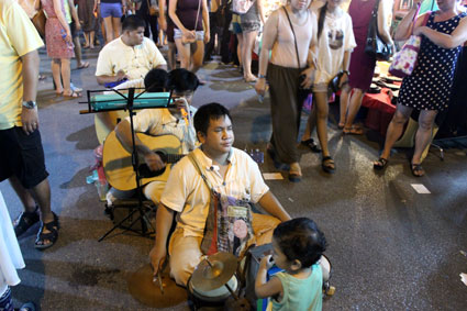 Un grupo de invidentes sentados en plena calle tocan y cantan durante el mercado callejero del Saturday Walking Street, (Chiang Mai).