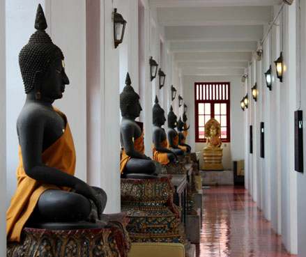 Varias estatuas de buda en uno de los pasillos del Loha Prasat, Bangkok.