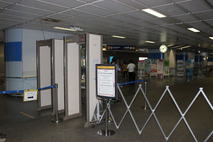 Arco de seguridad de la parada de metro de Sala Daeng. Un policía registra bolsas y mochilas de los usuarios (Bangkok).