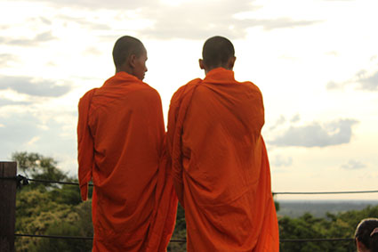 Dos monjes budistas observar el atardecer desde lo alto del templo