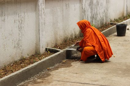 Un monje budista arregla la fachada de un templo en Pai, al norte de Tailandia.