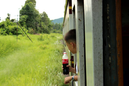 Un joven tailandés observa el paisaje desde el tren de Bangkok a Chiang Mai.