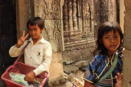 Dos niños venden de forma ambulante souvenirs entre los templos de Angkor Wat (Camboya). 